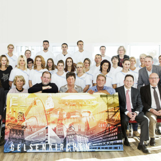 Teamfoto im Krankenhaus Gelsenkirchen: Pflegekräfte und Leitung posieren mit großem Stadt-Poster bei einer Veranstaltung