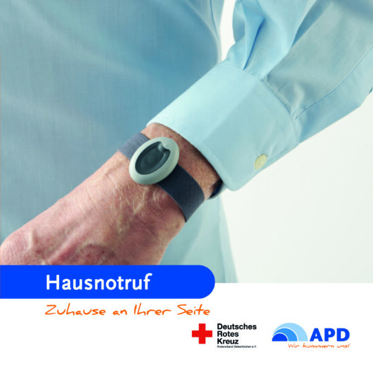 Hausnotruf-Armband mit Notfallknopf am Handgelenk eines Seniors – schnelle Hilfe zuhause, Deutsches Rotes Kreuz & APD.